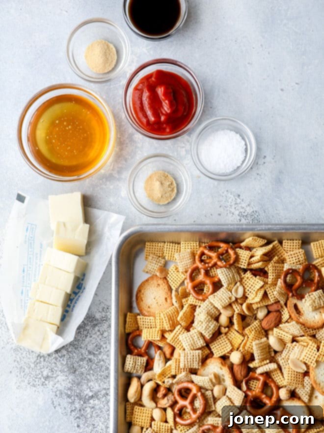 A baking sheet filled with sweet and spicy snack mix, freshly coated in glaze, ready for the oven.