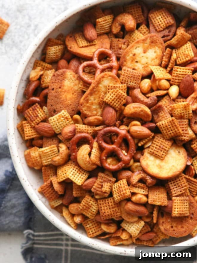 A portion of the finished sweet and spicy snack mix in a small white bowl, ready to be enjoyed.