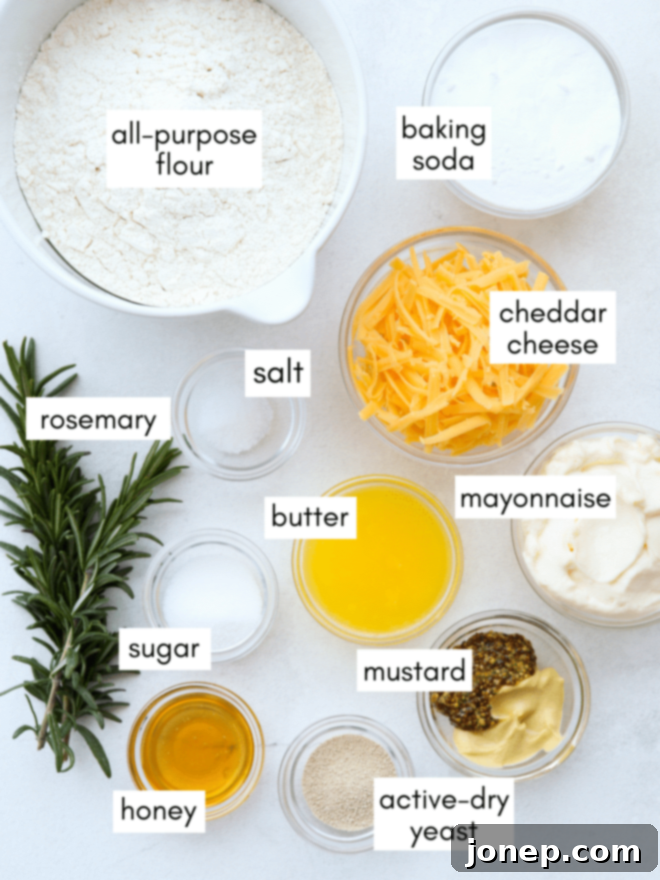 Ingredients for homemade pretzel bites including flour, yeast, butter, cheddar cheese, and fresh rosemary.