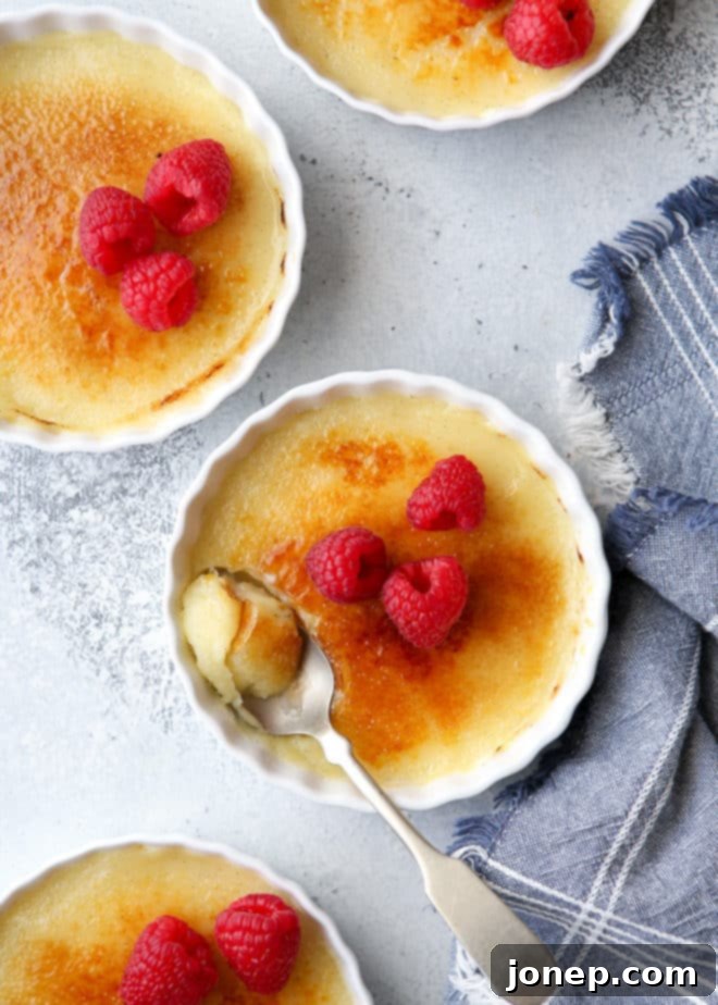 A serving of no-bake crème brûlée with the golden caramelized sugar crust already cracked, revealing the creamy custard below.