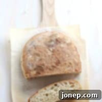 Savory Roasted Garlic Ciabatta 2 Two golden-brown loaves of Roasted Garlic Ciabatta Bread on a cutting board