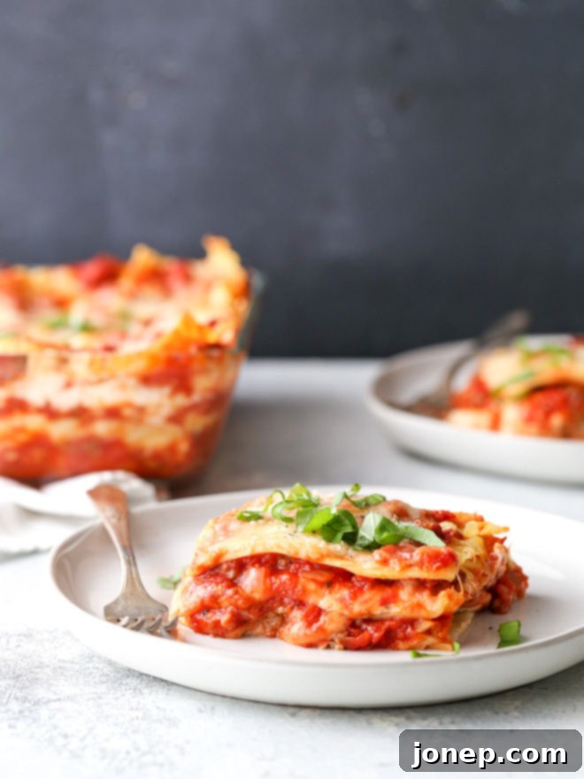 A perfectly baked classic meat lasagna, showcasing its golden-brown top and bubbling cheese. It's filled with layers of pasta, rich homemade meat sauce, and generous amounts of ricotta, mozzarella, and parmesan cheese.