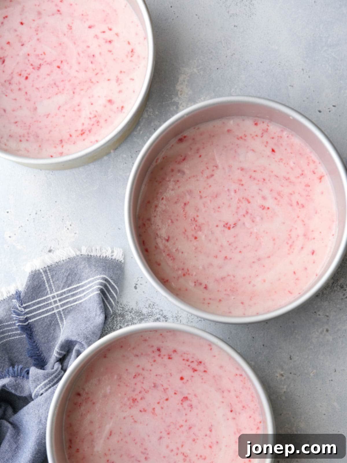 Prepared cherry chip cake batter with finely chopped maraschino cherries folded in, ready for baking.