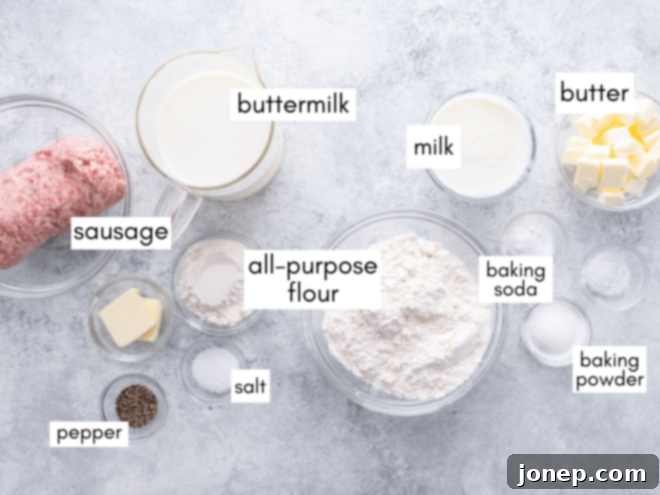 Fluffy Biscuits with Creamy Sausage Gravy 4 Various ingredients for biscuits and gravy, including butter, buttermilk, flour, and sausage, laid out on a wooden surface.