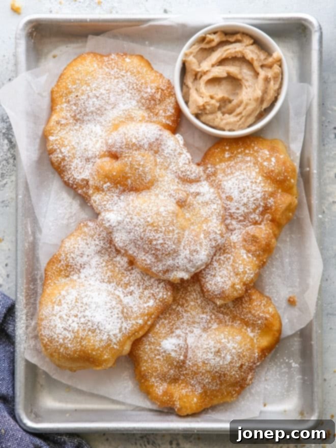 Golden Honey Cinnamon Fry Bread 2 fry bread on a pan with cinnamon honey butter in a bowl