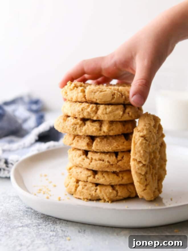 Simply 4-Ingredient Flourless Peanut Butter Cookies 3 hand taking cookie from stack on a plate