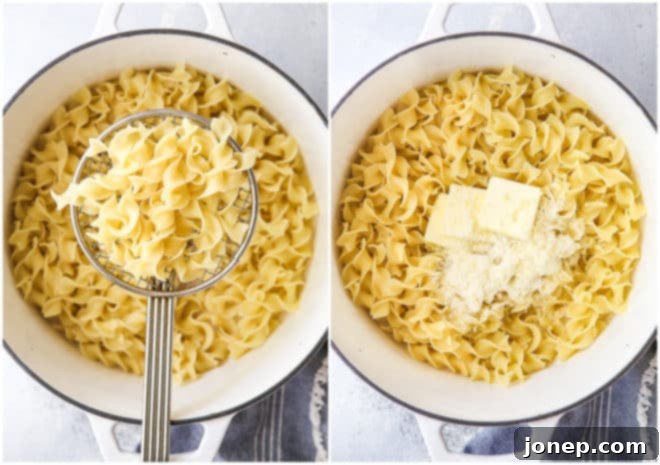 Hands stirring simple buttered noodles in a pot with melted butter and parmesan cheese, preparing to serve