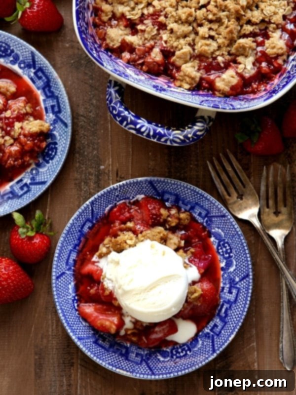 A freshly baked Strawberry, Rhubarb, and Raspberry Crisp with a golden, crunchy topping.