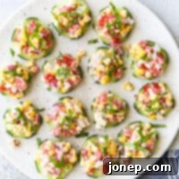 Individual cucumber bites topped with a corn and red pepper salad filled with feta, basil, and a creamy dressing.