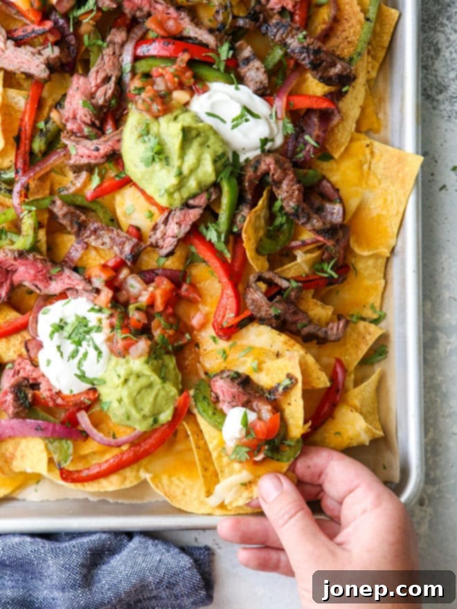 grabbing a bite of steak fajita nachos