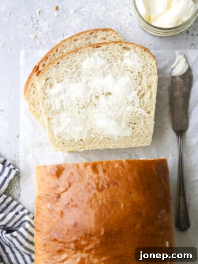 Soft white sandwich bread sliced and spread with butter, showcasing its tender texture