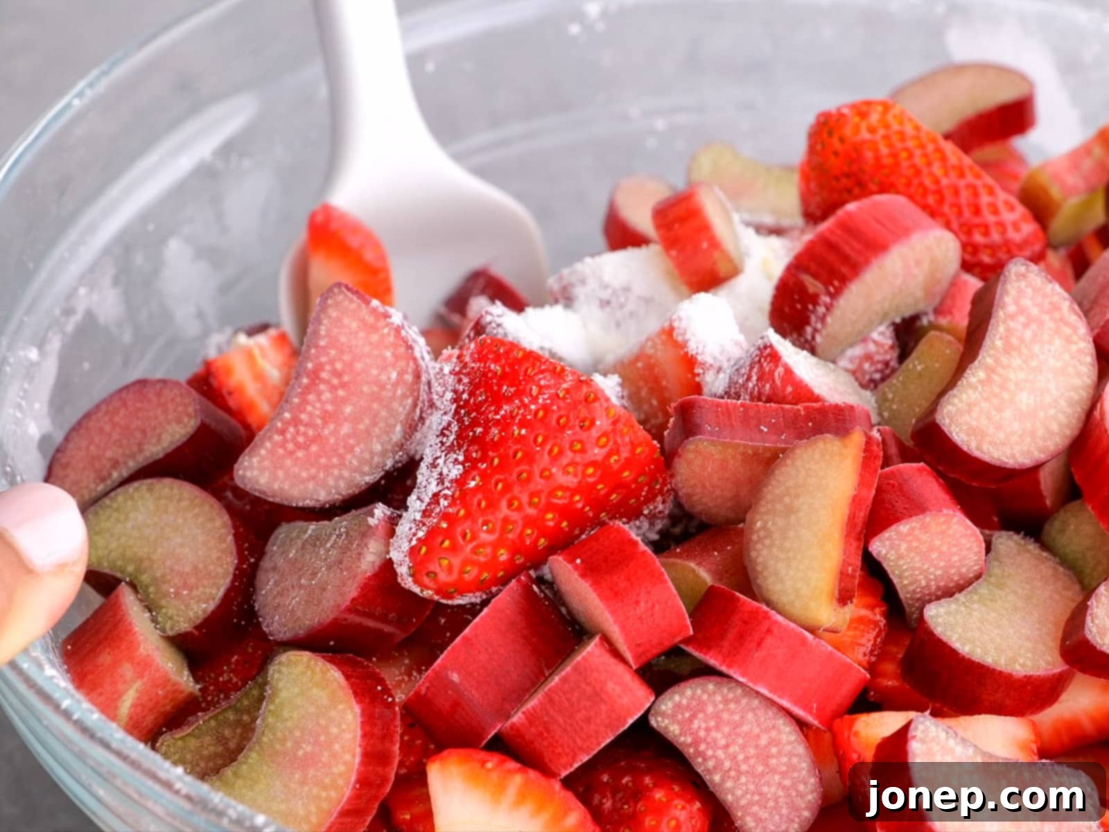 mixing strawberry rhubarb pie filling in a bowl