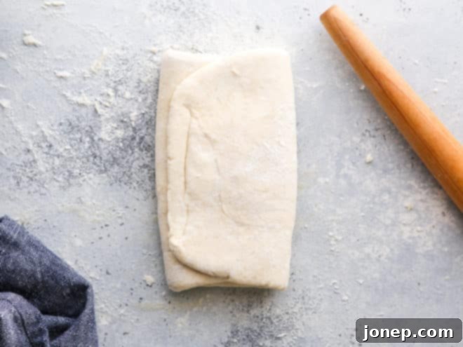 Finished homemade puff pastry dough resting on a table, smooth and ready for chilling or use.