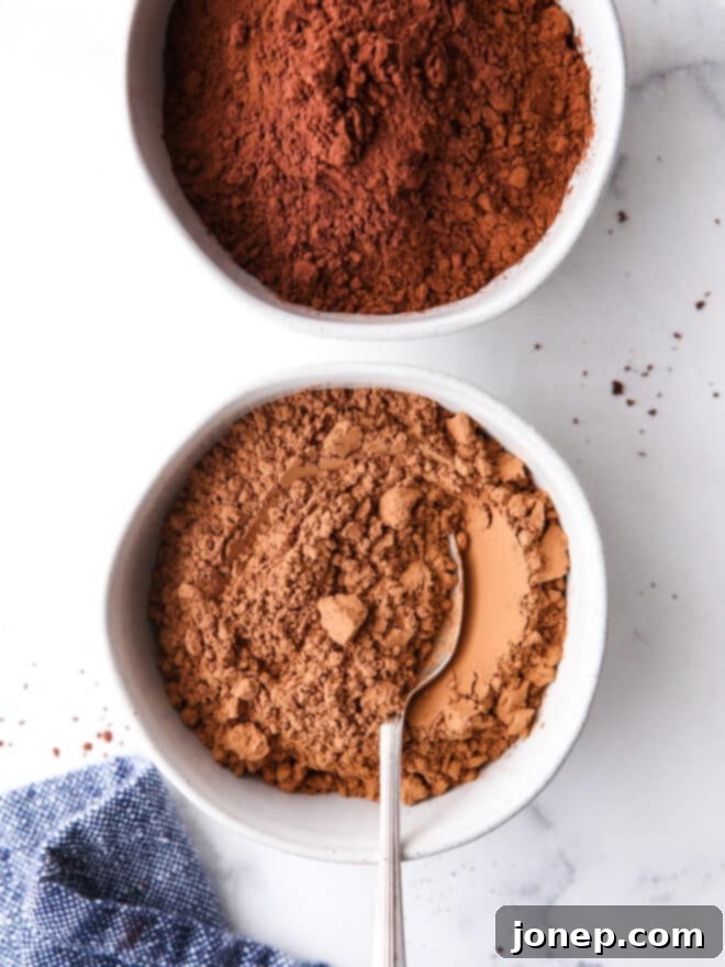 Two bowls side-by-side, one with natural unsweetened cocoa powder, the other with Dutch-process cocoa powder, highlighting their color differences.