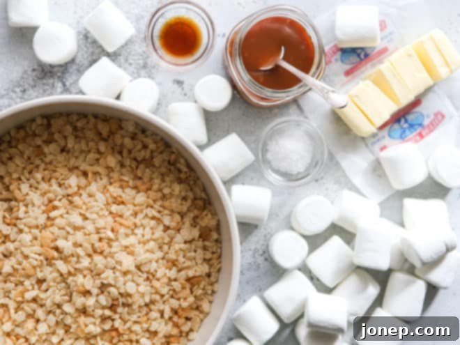Assortment of key ingredients for brown butter salted caramel rice krispie treats, including butter, marshmallows, and cereal.