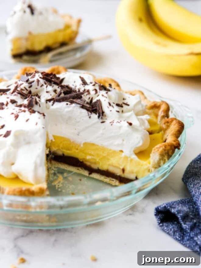 chocolate banana cream pie with slice taken out of it so you can see all the layers