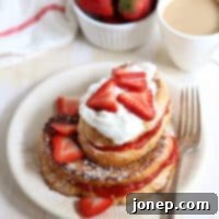 Sweet & Tart Strawberry-Rhubarb Stuffed French Toast 2 Strawberry-Rhubarb French Toast on a plate with garnishes