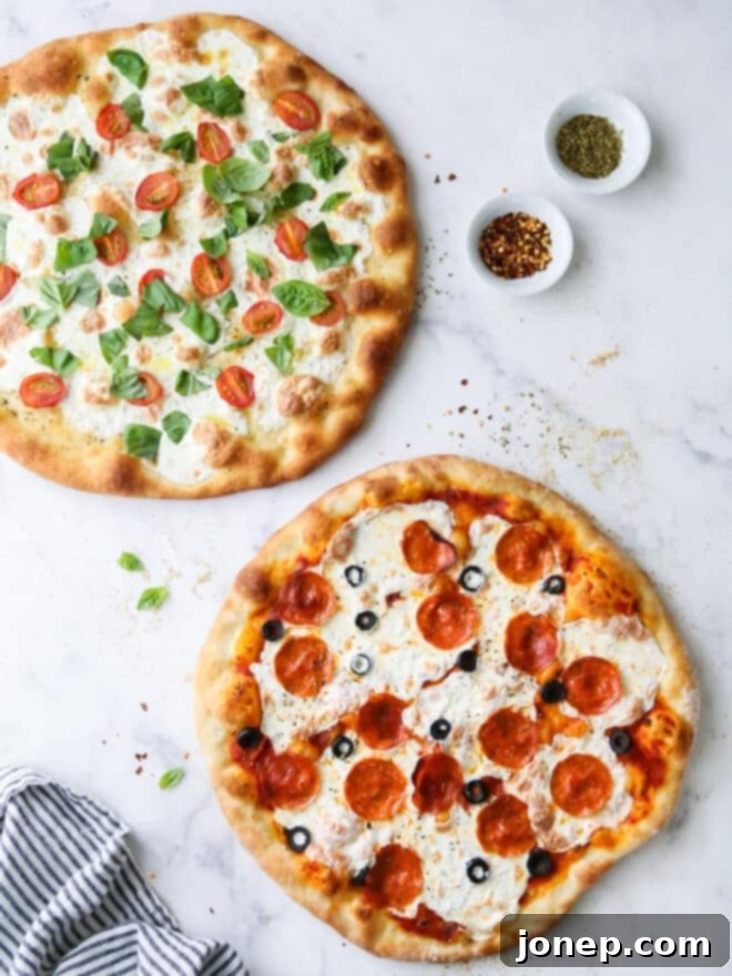 2 baked pizzas on table, pepperoni and caprese