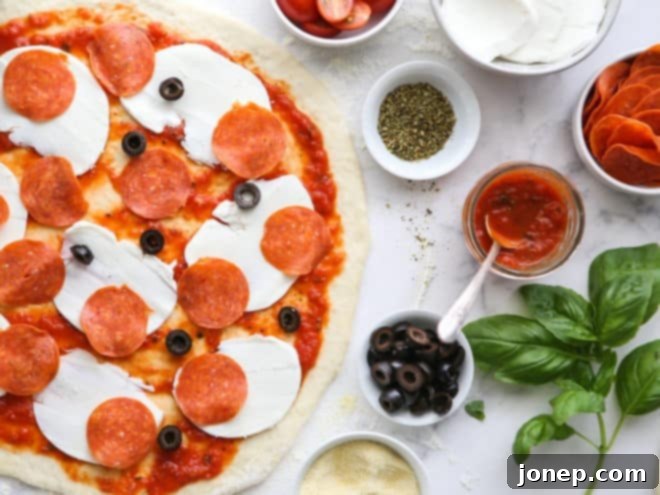 adding pepperoni pizza toppings to pizza dough
