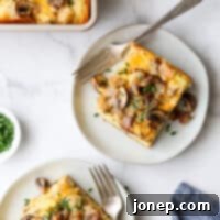 Two slices of the finished sausage and mushroom breakfast casserole on white plates.