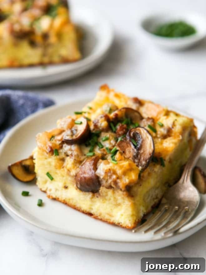 Close-up view of a perfectly baked slice of sausage and mushroom breakfast casserole, showing layers and texture.