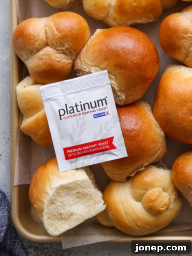 A close-up of a freshly baked dinner roll in the foreground, with a Red Star Yeast packet visible in the background, reinforcing the brand partnership.