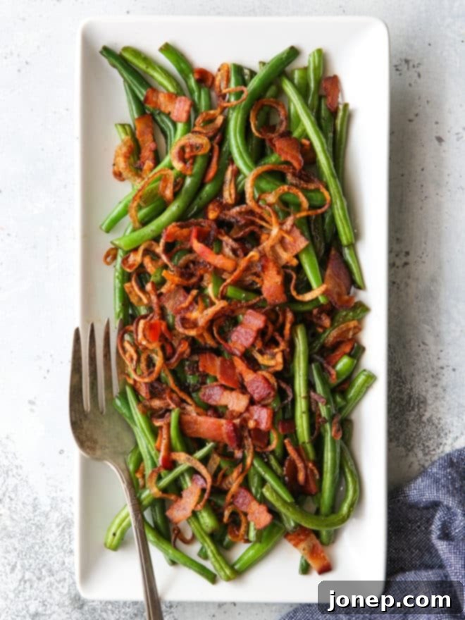 green beans with crispy shallots and bacon on a platter with fork