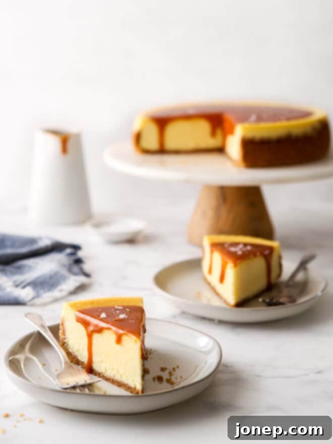 slices of salted caramel cheesecake on a plate with cake stand in background