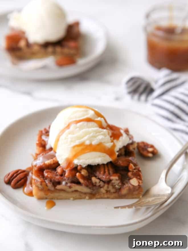 pecan pie bar with ice cream and caramel drizzle on a plate