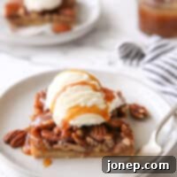 Rich Pecan Pie Bars 8 pecan pie bar with ice cream and caramel drizzle on a plate