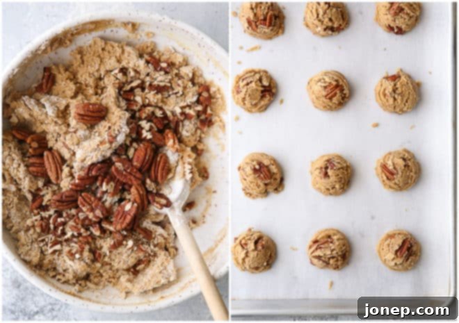 Close-up of brown butter pecan cookie dough in a large mixing bowl, showing the incorporated toasted pecans and rich, thick texture.