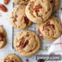 Irresistible Brown Butter Pecan Cookies 8 A beautifully arranged stack of freshly baked brown butter pecan cookies, garnished with a sprinkle of coarse sea salt.