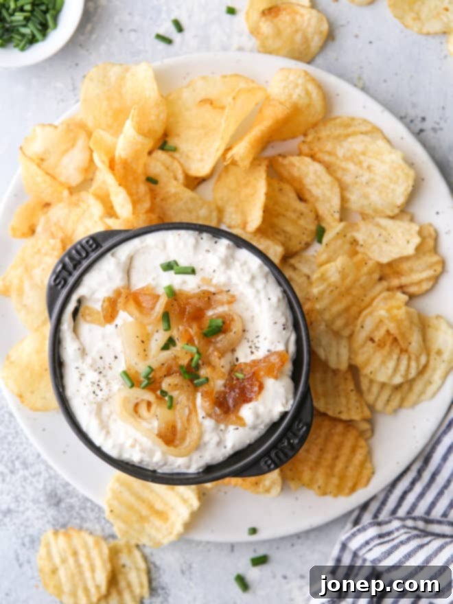 bowl of french onion dip with chips, garnished with chives