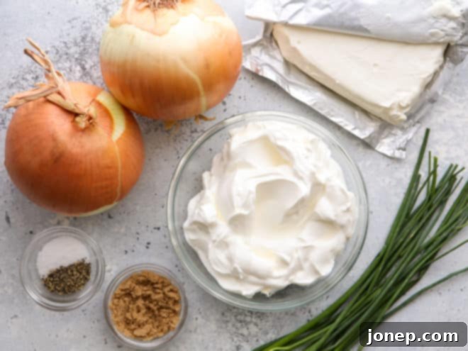 homemade french onion dip ingredients laid out: butter, onions, cream cheese, sour cream, brown sugar, salt, pepper, chives