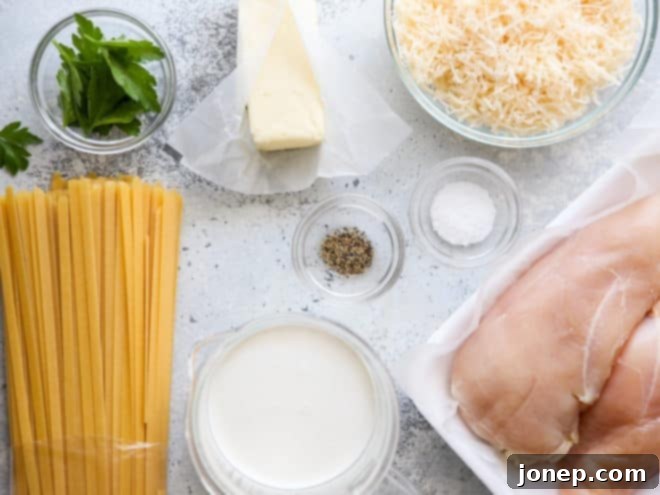 Essential ingredients for homemade chicken fettuccine alfredo laid out on a kitchen counter.