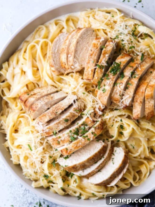 A close-up shot of creamy chicken fettuccine alfredo in a bowl, showing the rich sauce and tender chicken.