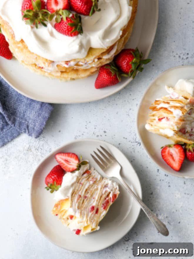 slices of strawberries and cream crepe cake on plates