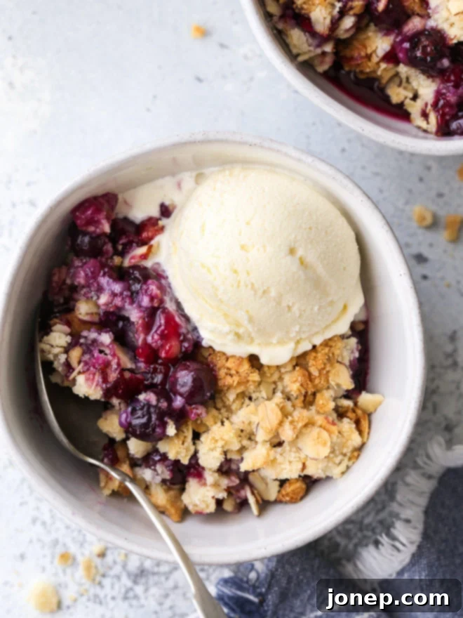 Sweet Berry Almond Delight 2 A beautifully baked blueberry almond crisp with a juicy berry filling and crunchy almond-oat topping, ready to be served. Perfect for summer gatherings.