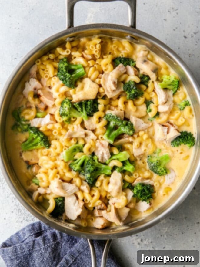 chicken broccoli macaroni and cheese in a skillet with towel