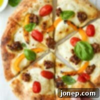 a hand taking a piece of italian sausage pizza