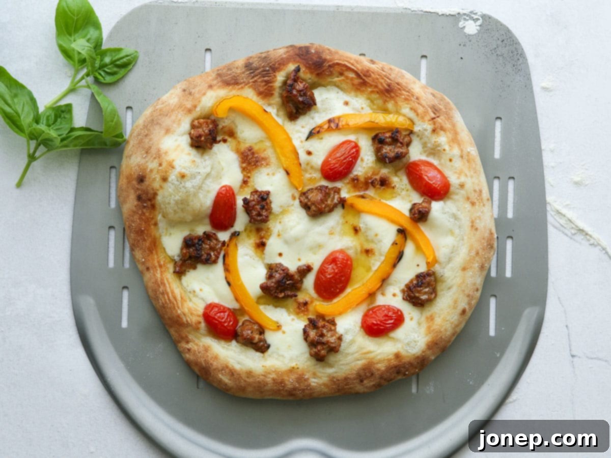 baked italian sausage pizza on pizza peel