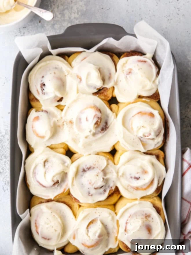 Festive Eggnog Cinnamon Rolls 2 Freshly baked eggnog cinnamon rolls with creamy icing in a baking dish.