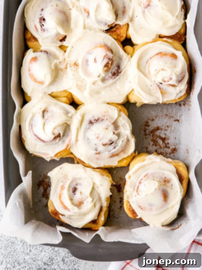 Festive Eggnog Cinnamon Rolls 7 Close-up of a single eggnog cinnamon roll with luscious frosting.