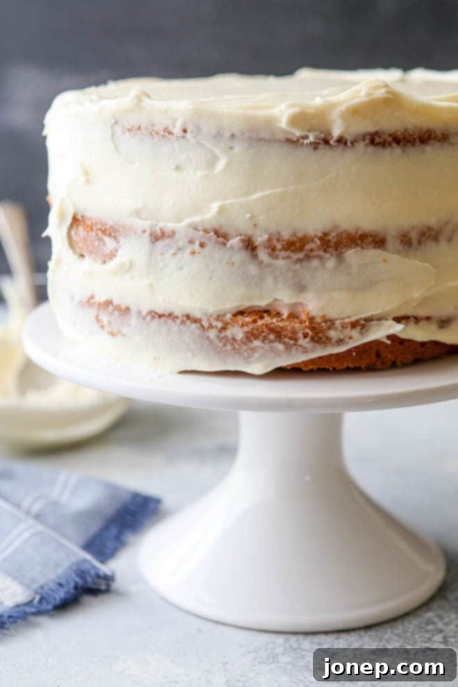 A close-up of a bowl filled with incredibly creamy, light cream cheese frosting, ready to be spread.