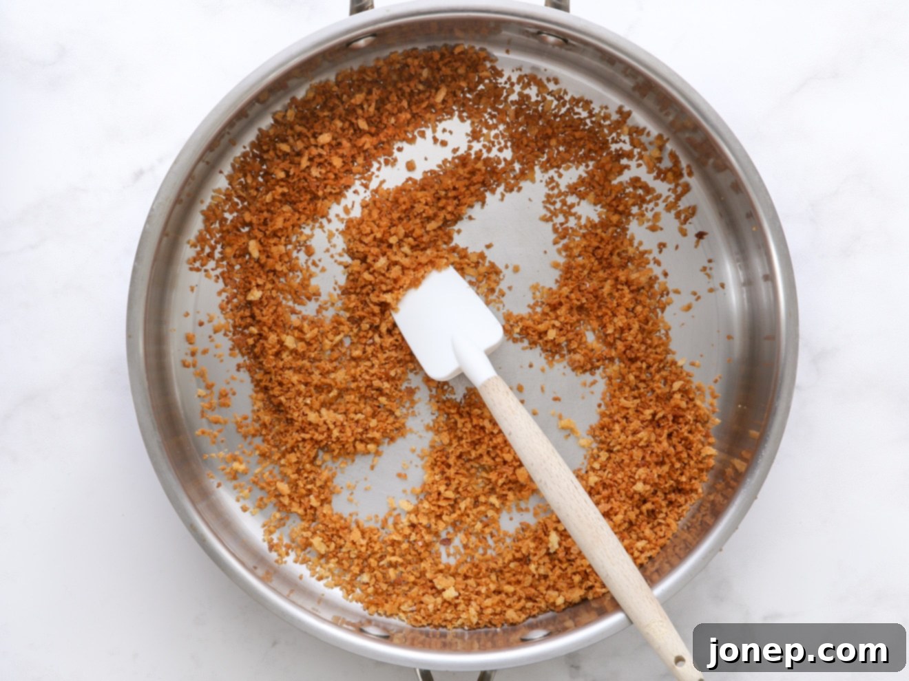 Step 1: Toasting Panko breadcrumbs in olive oil until golden brown.