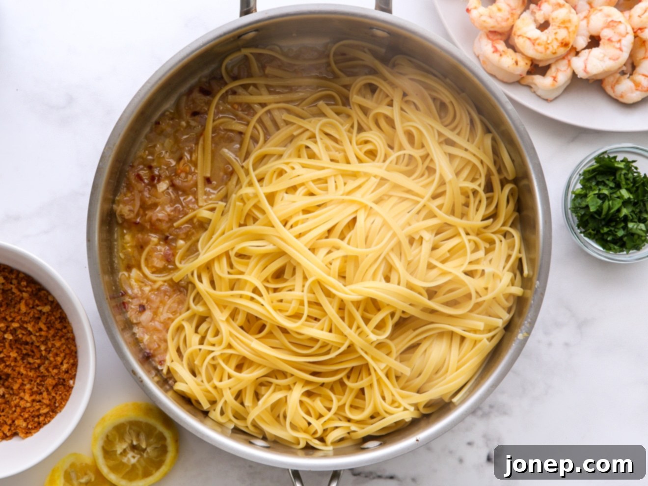 Step 3: Creating the lemon garlic butter sauce in a skillet, with pasta being added.