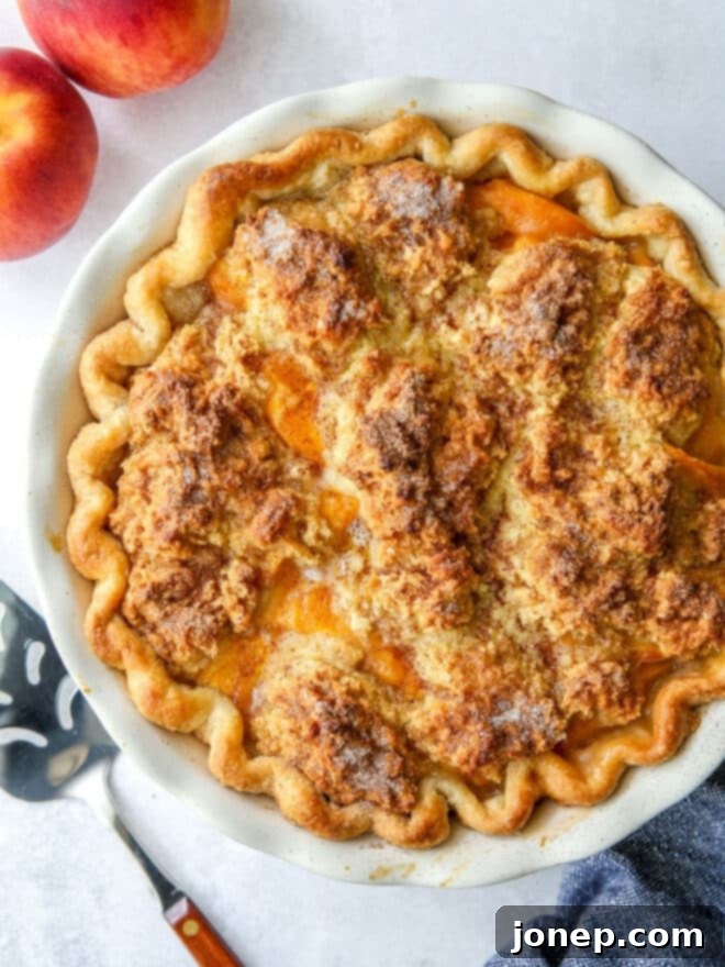 closeup of peach cobbler pie, showcasing its golden crust and biscuit topping