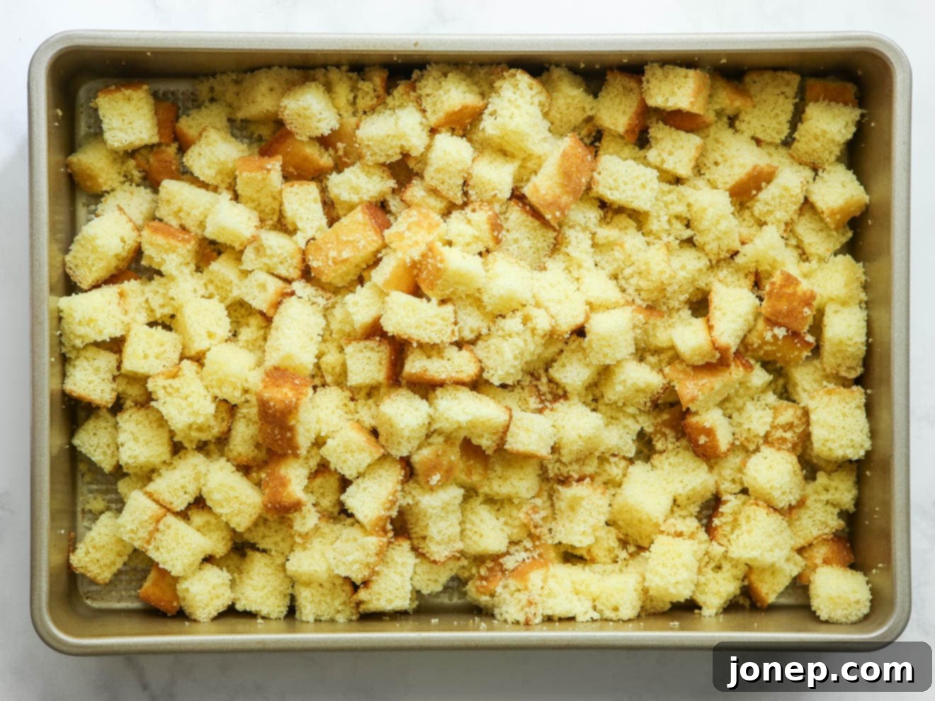 Vanilla cake cut into uniform cubes, ready for layering.