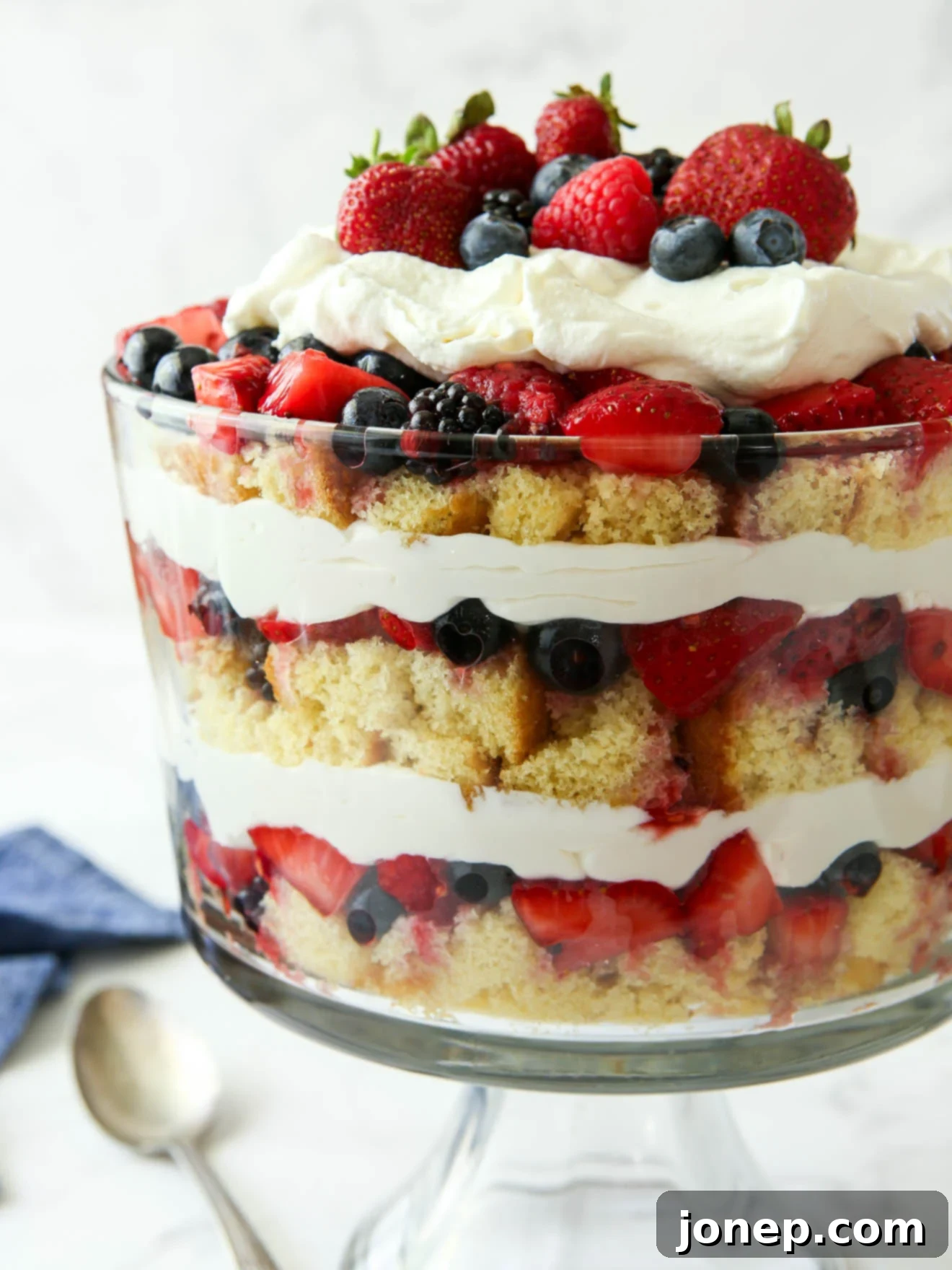 Layers of Summer Berry Bliss 9 Close-up view of a beautifully layered summer berry trifle, showcasing the vibrant colors and textures.