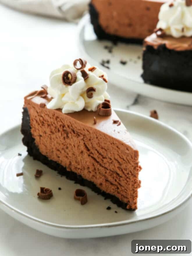 Effortless Chocolate Cheesecake Bliss 3 Close-up of a slice of no-bake chocolate cheesecake on a plate, showing the creamy filling and Oreo crust.
